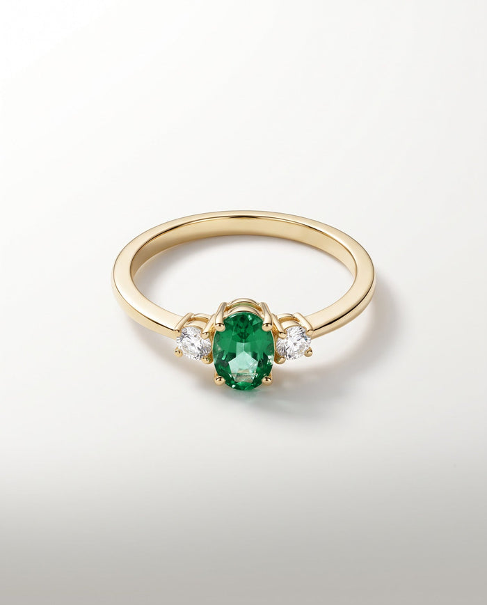 Bague Trilogie, émeraude ovale vert profond et deux diamants, or jaune — packshot
