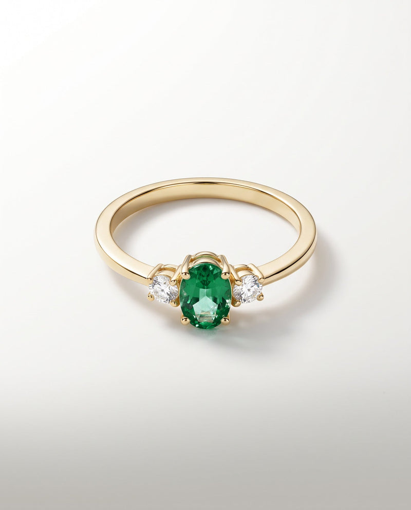 Bague Trilogie, émeraude ovale vert profond et deux diamants, or jaune — packshot