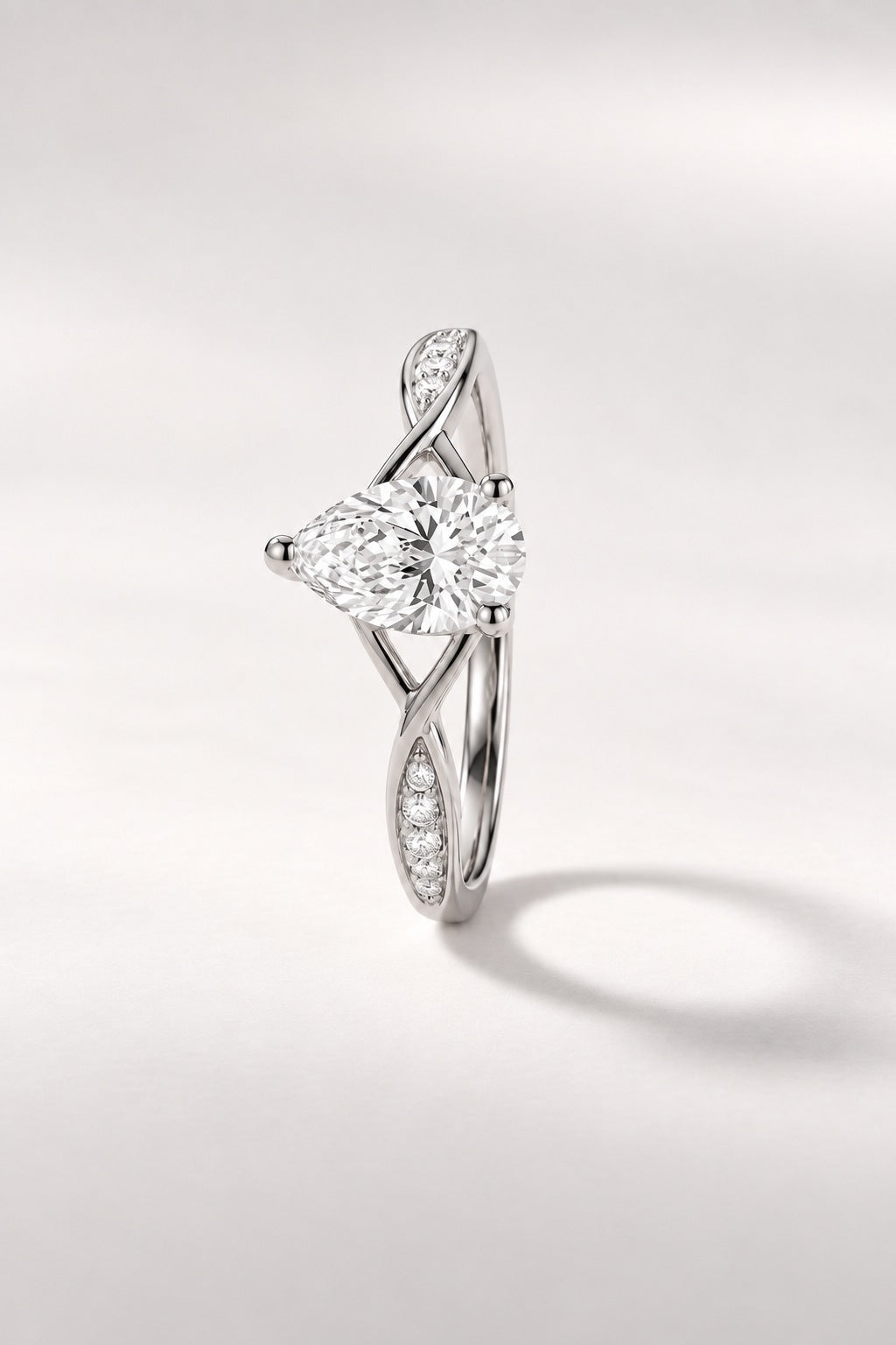 Bague Infini — diamant poire créé en laboratoire sur anneau croisé pavé, or blanc — vue trois quarts