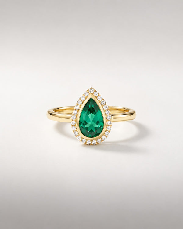 Bague Ocelle — émeraude poire créée en laboratoire en serti clos, halo de diamants, or jaune — vue de face