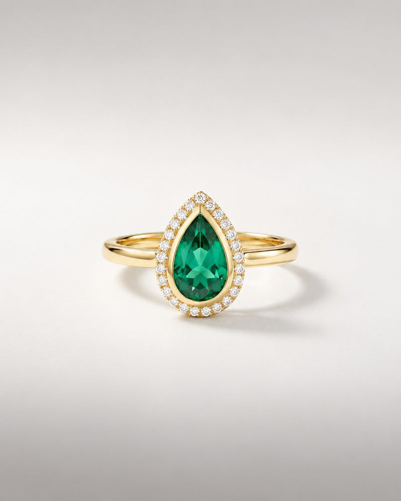 Bague Ocelle — émeraude poire créée en laboratoire en serti clos, halo de diamants, or jaune — vue de face