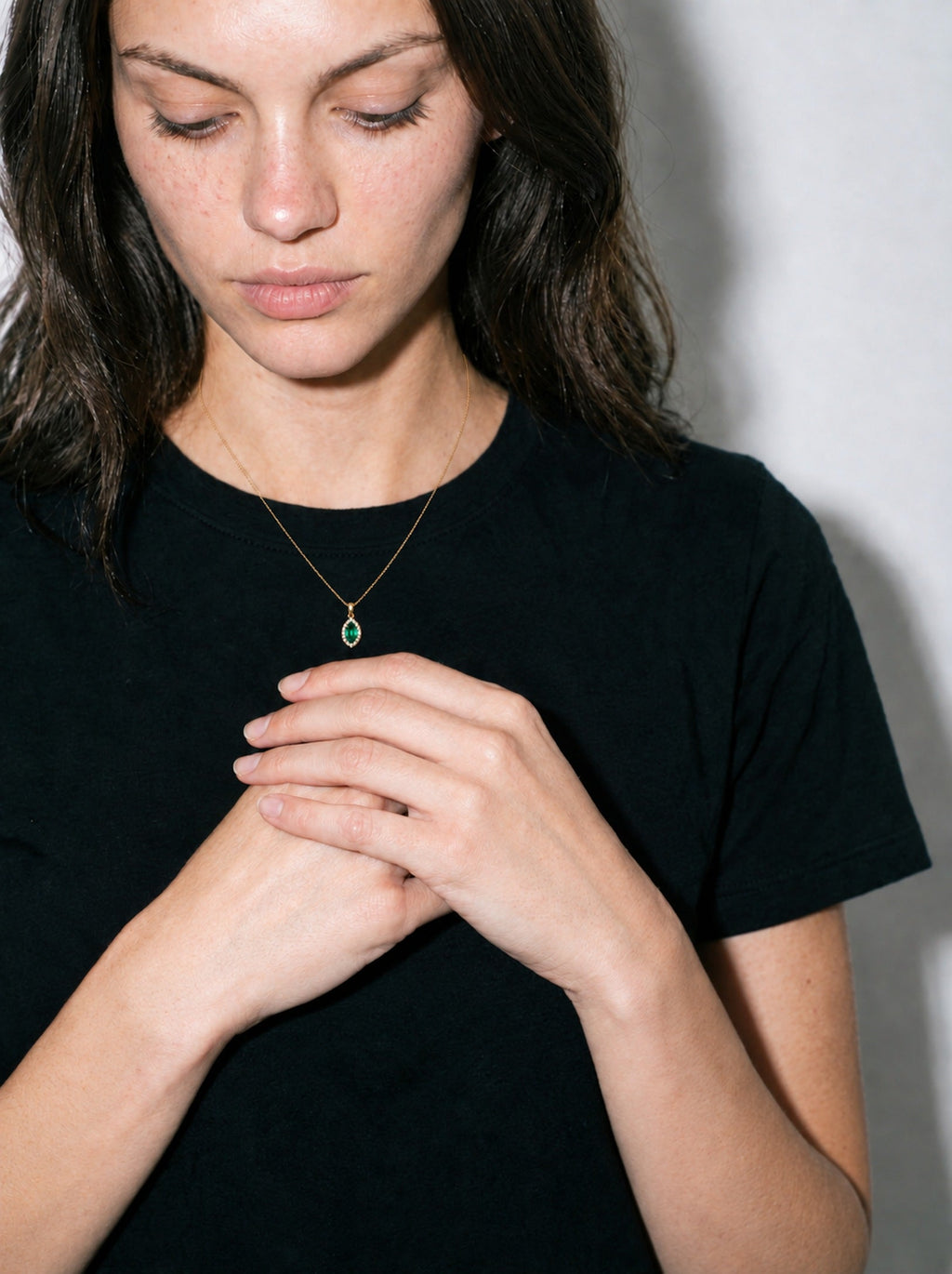 Collier Ocelle porté, t-shirt noir, pendentif émeraude marquise et halo de diamants, or jaune