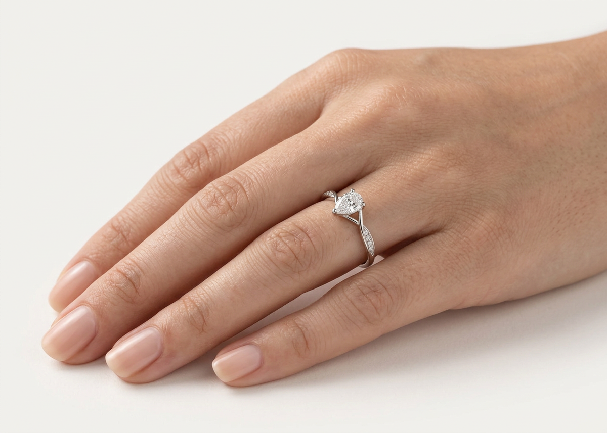 Bague Infini portée à l'annulaire — diamant poire sur anneau croisé pavé, or blanc — Carron Olivier