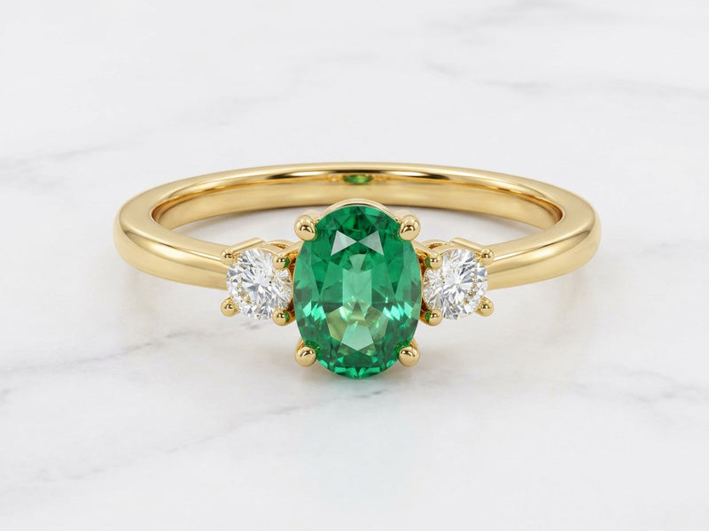 Bague Trilogie, émeraude ovale entre deux diamants, or jaune — Carron Olivier
