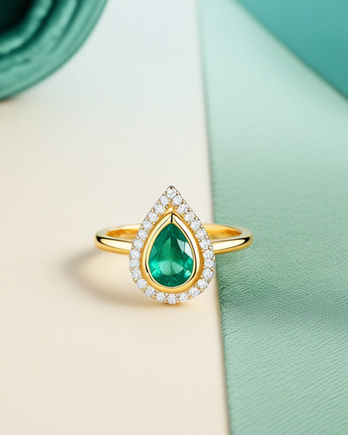 Bague Ocelle — émeraude de synthèse taille poire, halo de diamants, or jaune massif — Carron Olivier